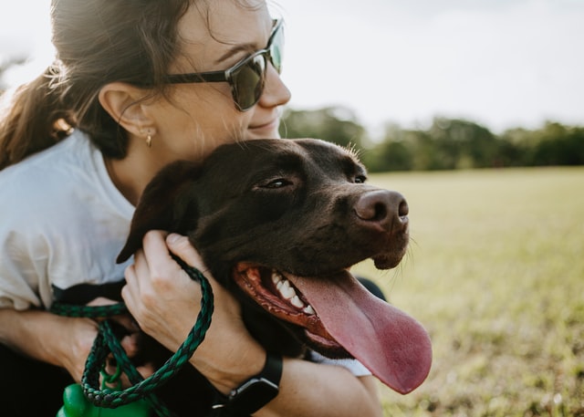 A woman hugs her dog.