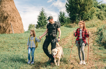 A family hikes with their dog.